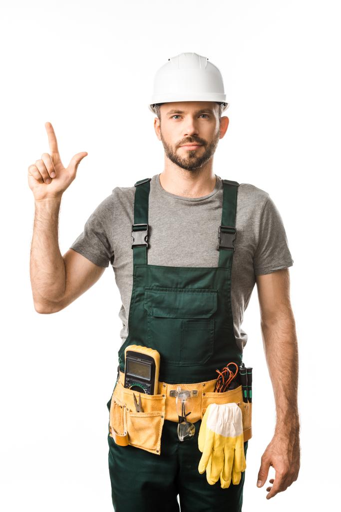 hezký elektrikář s pásem nástroj směřující nahoru izolované na bílém - Fotografie, Obrázek