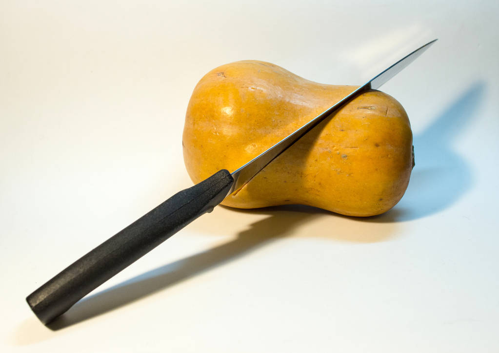 Oranžové dýně na bílém pozadí je řez s nožem. Zelenina jako symboly svátků.  - Fotografie, Obrázek