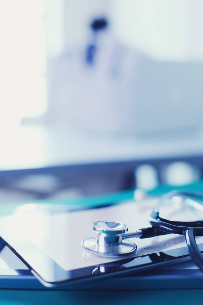 Medische apparatuur: blauwe stethoscoop en tablet op witte achtergrond. Medische apparatuur - Foto, afbeelding