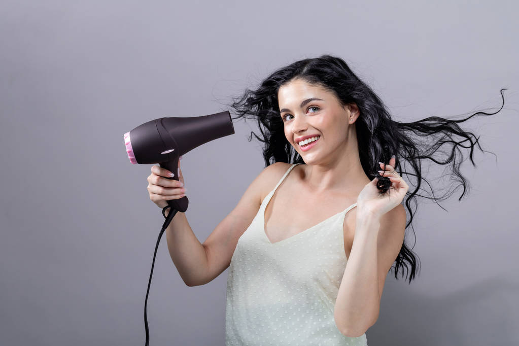schöne junge Frau mit einem Haartrockner - Foto, Bild