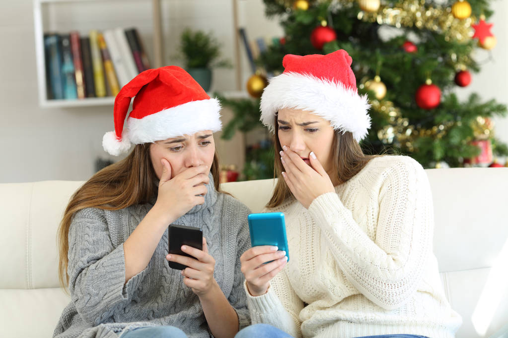 Mujeres preocupadas leyendo malas noticias en Navidad sentadas en un sofá en la sala de estar en casa
 - Foto, imagen