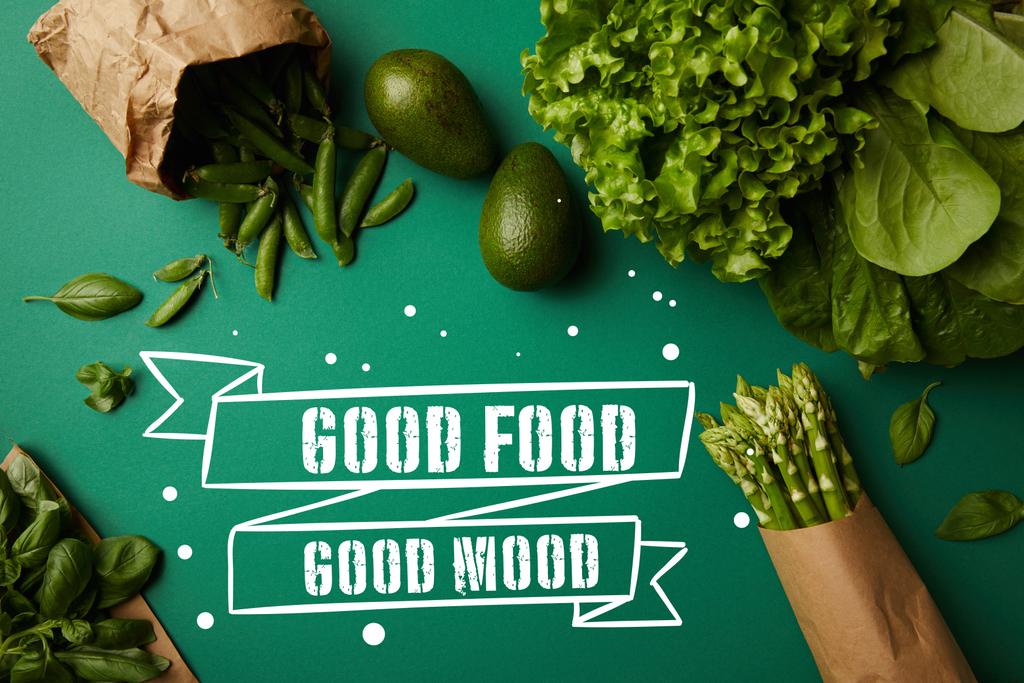 top view of different green ripe vegetables on green surface with "good food - good mood" inspiration - Photo, Image