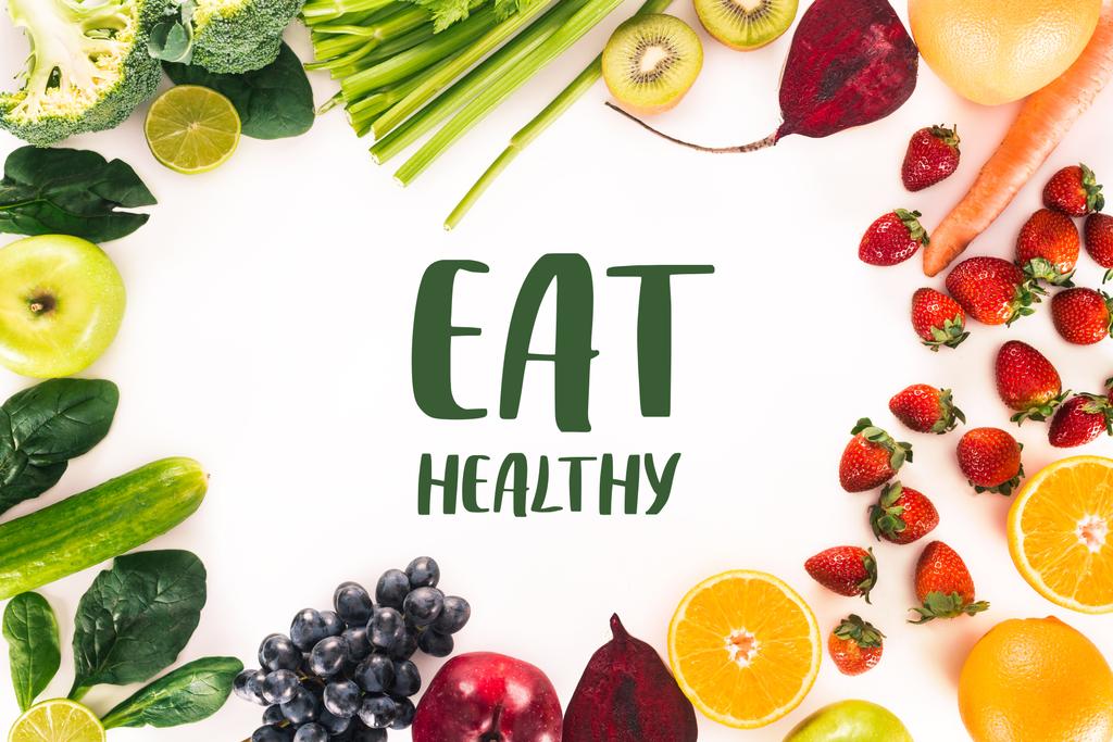 felülnézet elrendezése a friss zöldségek, gyümölcsök és bogyók elszigetelt fehér betűkkel "enni egészséges." - Fotó, kép