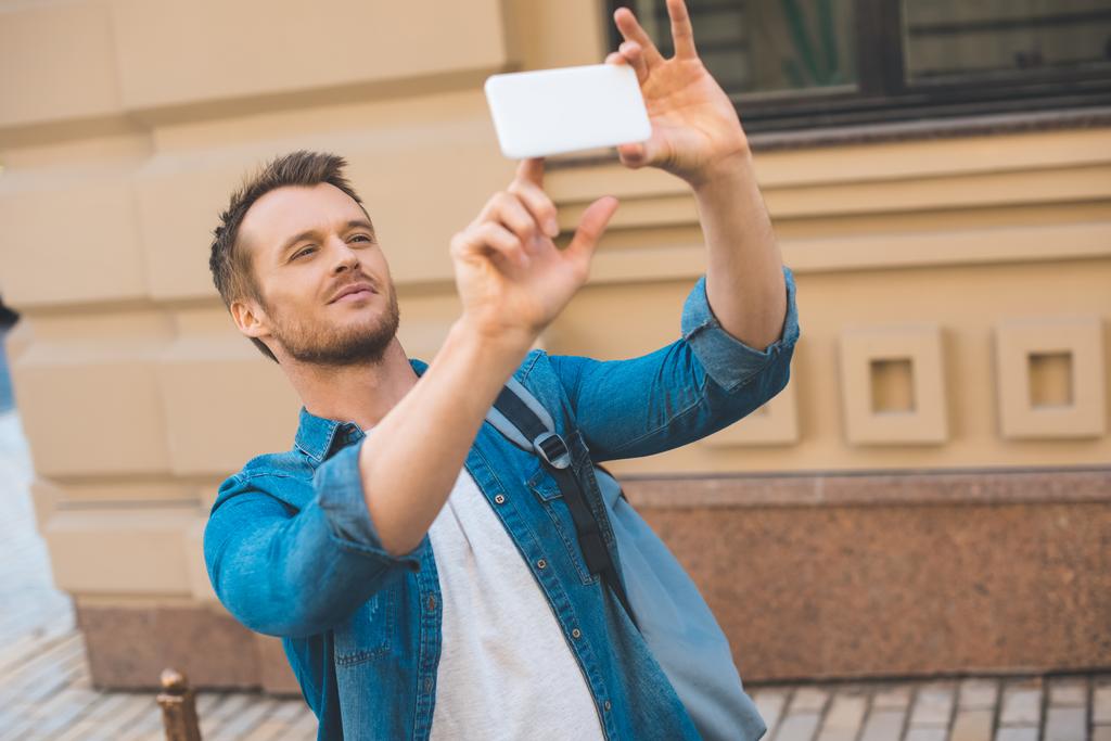 attraente giovane turista con zaino scattare foto con smartphone sulla strada
 - Foto, immagini