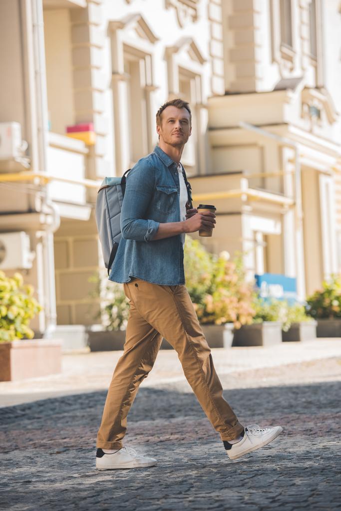 行くし、市による歩行をバックパックにコーヒーとハンサムな若い男 - 写真・画像