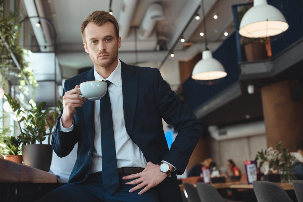 портрет стильного бизнесмена в костюме с чашкой кофе на перерыв в кафе
 - Фото, изображение