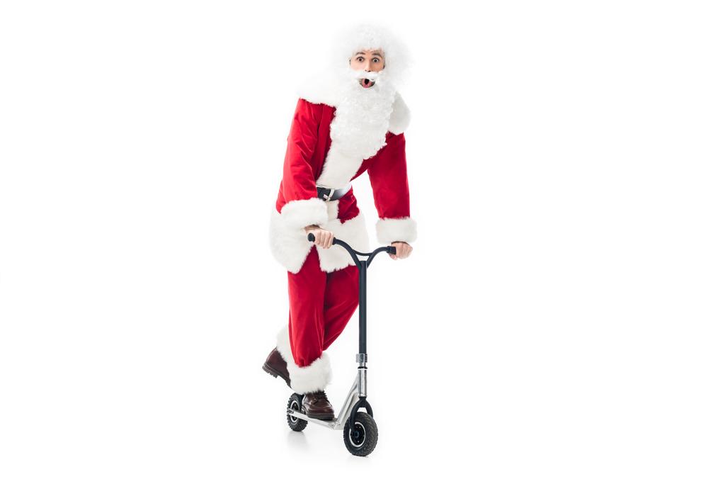 Schockierter Weihnachtsmann im Kostüm auf Tretroller auf weißem Hintergrund - Foto, Bild