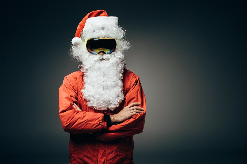 Noel Baba kar maskesi ve çapraz kolları üzerinde gri arka plan izole olan ayakta rüzgarlık  - Fotoğraf, Görsel
