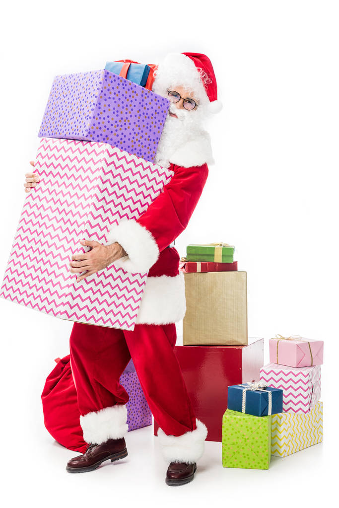 Άγιος Βασίλης σε γυαλιά κρατώντας σωρό κουτιά δώρων που απομονώνονται σε λευκό φόντο  - Φωτογραφία, εικόνα