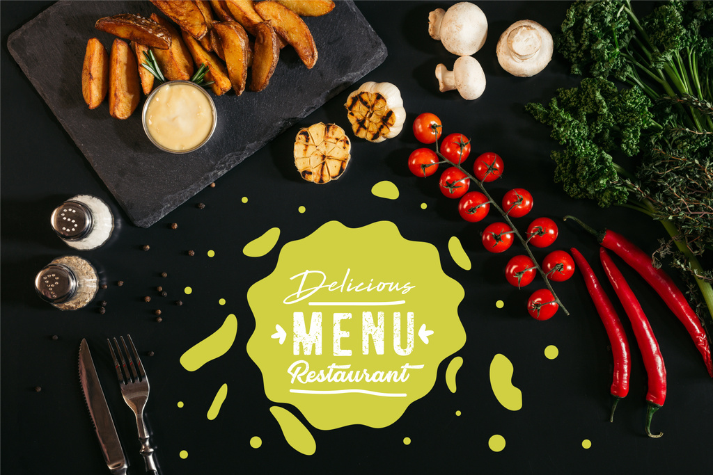 top view of tasty baked potatoes with sauce, spices and vegetables on black with "delicious menu restaurant" lettering  - Photo, Image