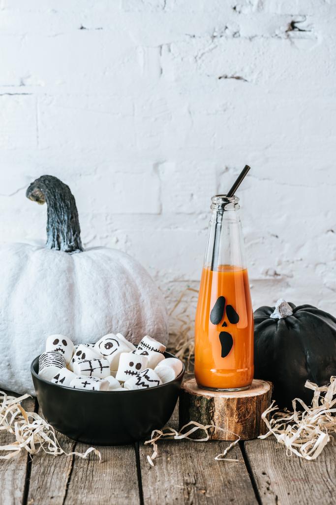 primer plano de composición de halloween con calabazas, malvaviscos y botella de jugo de calabaza
 - Foto, imagen