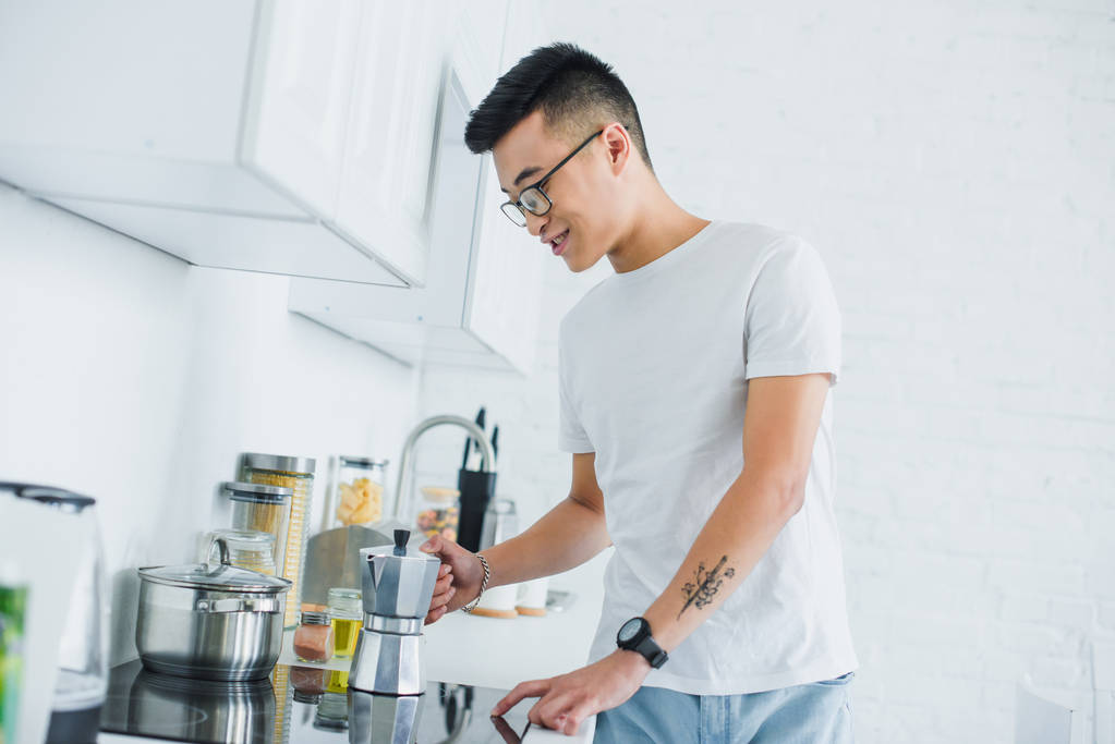 bonito sorrindo jovem asiático homem fazendo café no cozinha
 - Foto, Imagem