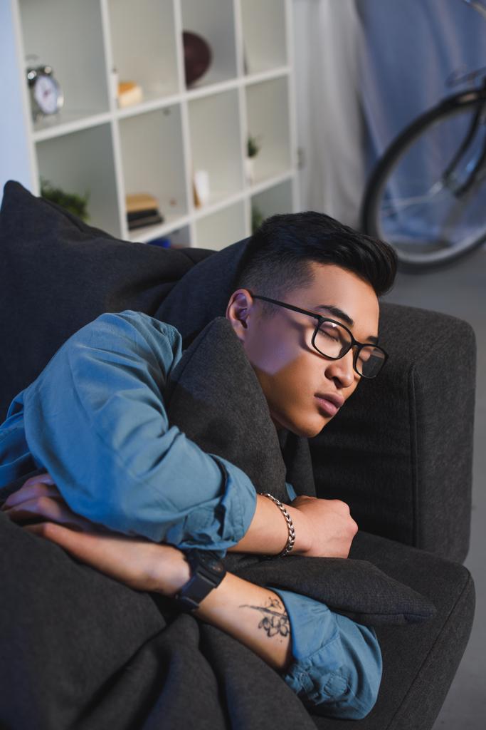 guapo joven asiático hombre en gafas durmiendo en sofá en casa
   - Foto, imagen
