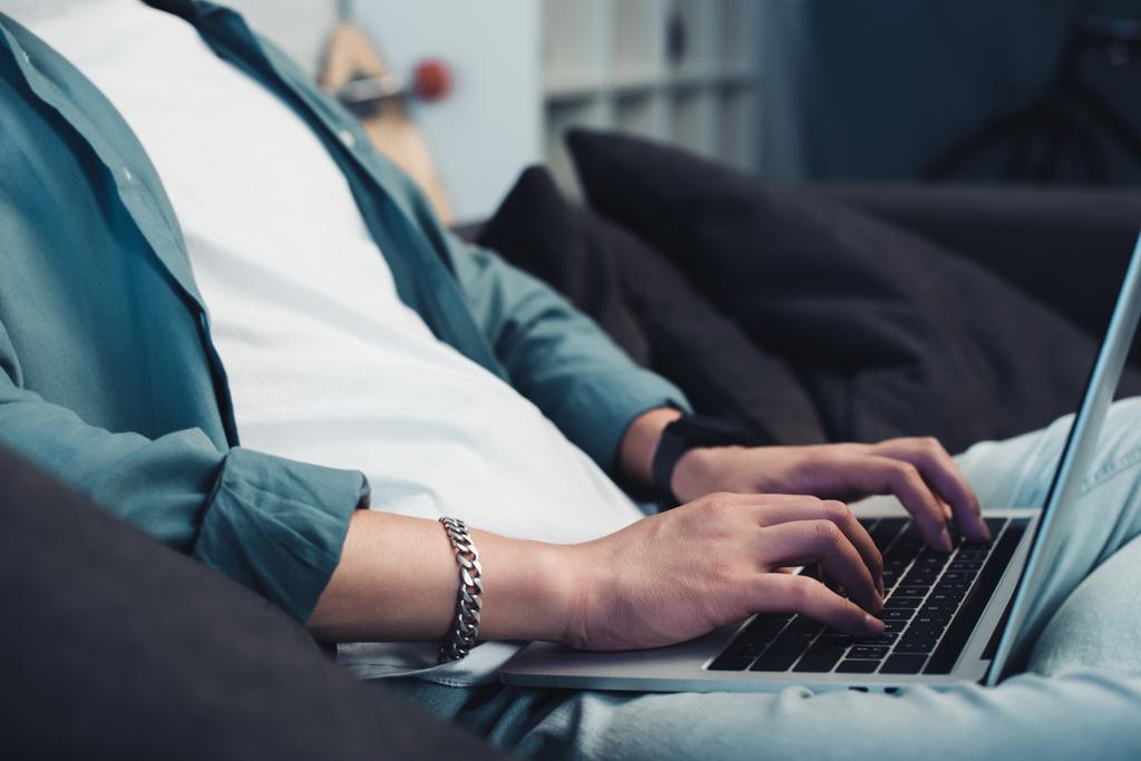 rajattu kuva nuori mies käyttää kannettavaa tietokonetta kotona
 - Valokuva, kuva
