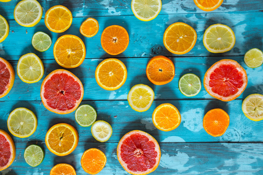 Citrusvruchten sinaasappel, citroen, grapefruit, mandarijn, limoen op blauwe achtergrond - Foto, afbeelding