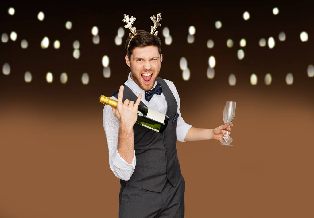 man met fles champagne op kerstfeest - Foto, afbeelding