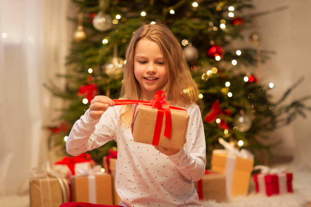 lachende meisje met de gift van Kerstmis thuis - Foto, afbeelding