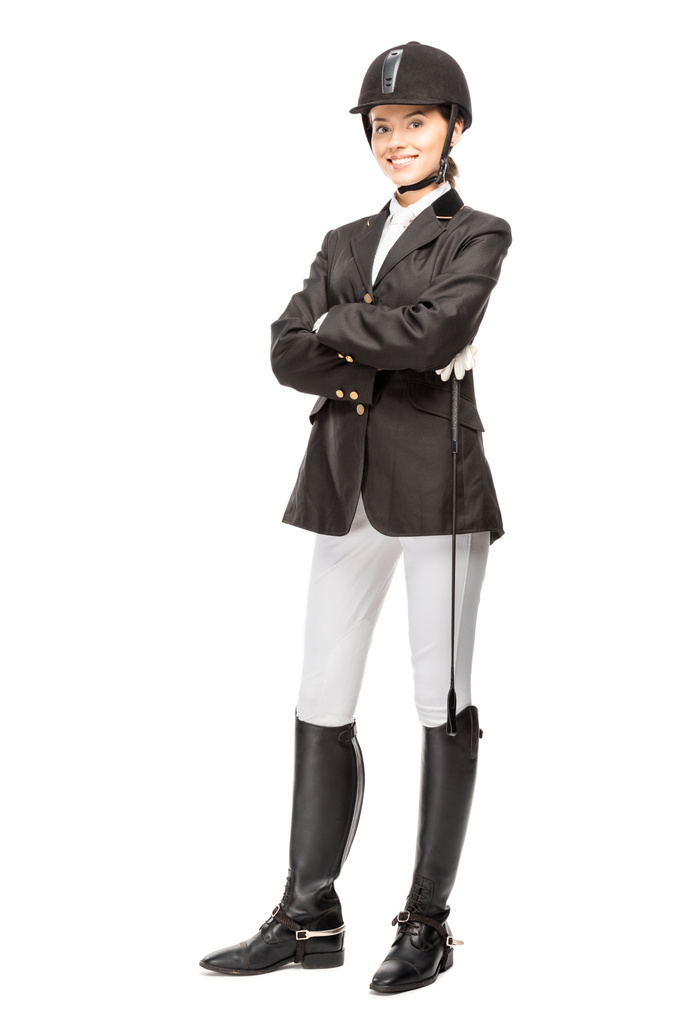 happy young horsewoman in uniform holding horseman stick and looking at camera isolated on white - Photo, Image