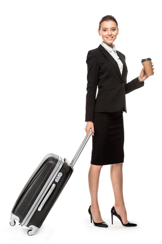 bela jovem empresária em terno com bagagem e xícara de papel de café olhando para a câmera isolada no branco
 - Foto, Imagem