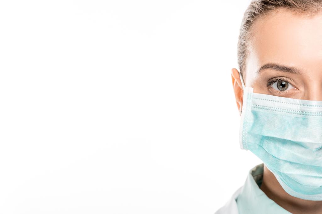 immagine ritagliata di giovane medico donna in maschera medica guardando la fotocamera isolata su bianco
 - Foto, immagini