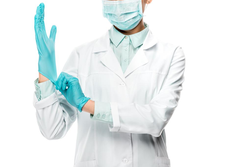 cropped image of female doctor in medical mask putting on latex gloves isolated on white - Photo, Image