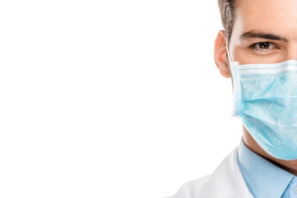 körülvágott kép a fiatal férfi orvos orvosi maszkot elszigetelt fehér  - Fotó, kép