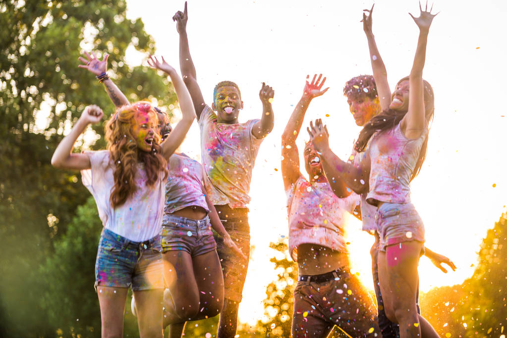 Группа счастливых друзей, играющих цветами цвета холи в парке - Молодые люди веселятся на фестивале холи, концепция веселья, веселья и молодого поколения
 - Фото, изображение