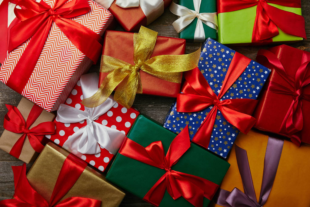 lapos feküdt a karácsonyi ajándékokat csomagolva különböző papírok szalagok a fa felülettel - Fotó, kép