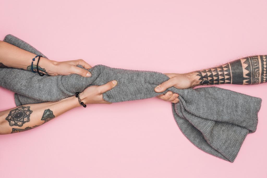 vista cortada de clientes tatuados puxando lenço quente isolado em rosa
 - Foto, Imagem