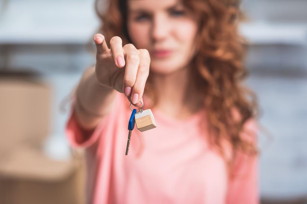 γκρο πλαν θέα της νεαρής γυναίκας που κρατά το κλειδί από το νέο σπίτι - Φωτογραφία, εικόνα