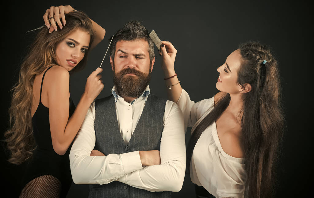 Friends at hairdresser salon, lgbt. People make haircut, love relations, friendship. Bearded man, sexy women with long hair. Barbershop, fashion, beauty, hipster. Women with comb scissors cut hair - Photo, Image