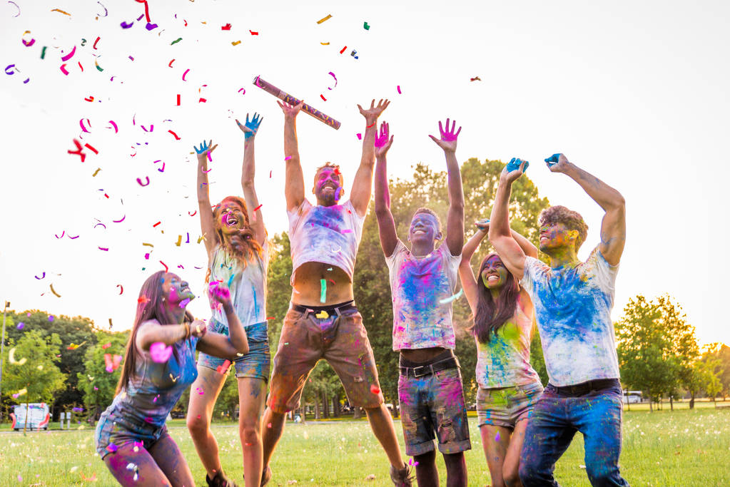 Grupo de amigos felices jugando con colores holi en un parque - Adultos jóvenes divirtiéndose en un festival holi, conceptos sobre diversión, diversión y generación joven
 - Foto, imagen