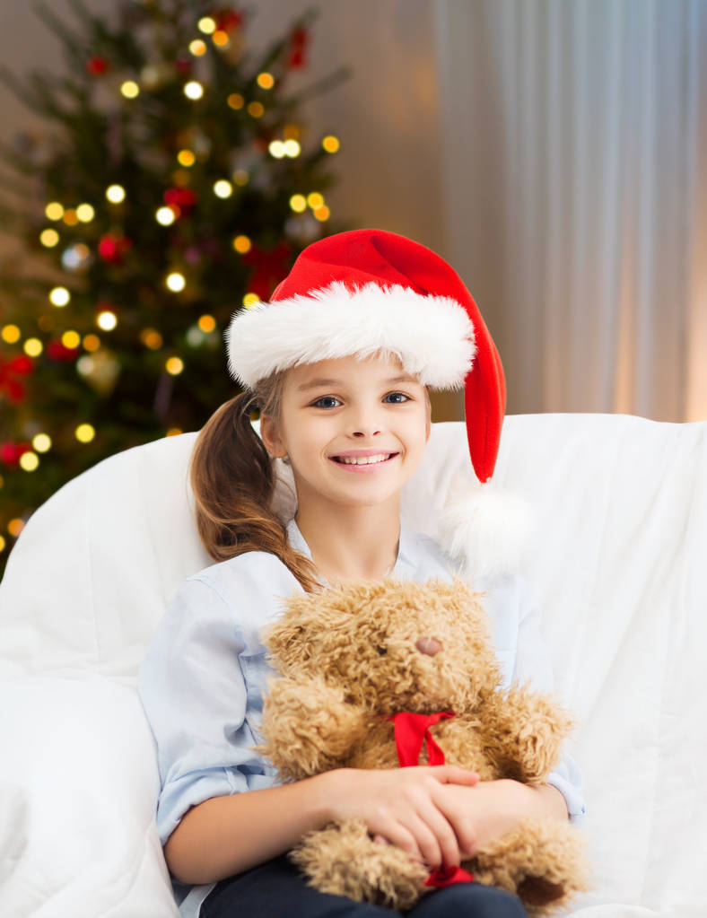 hymyilevä pieni tyttö nallekarhun kanssa jouluna
 - Valokuva, kuva