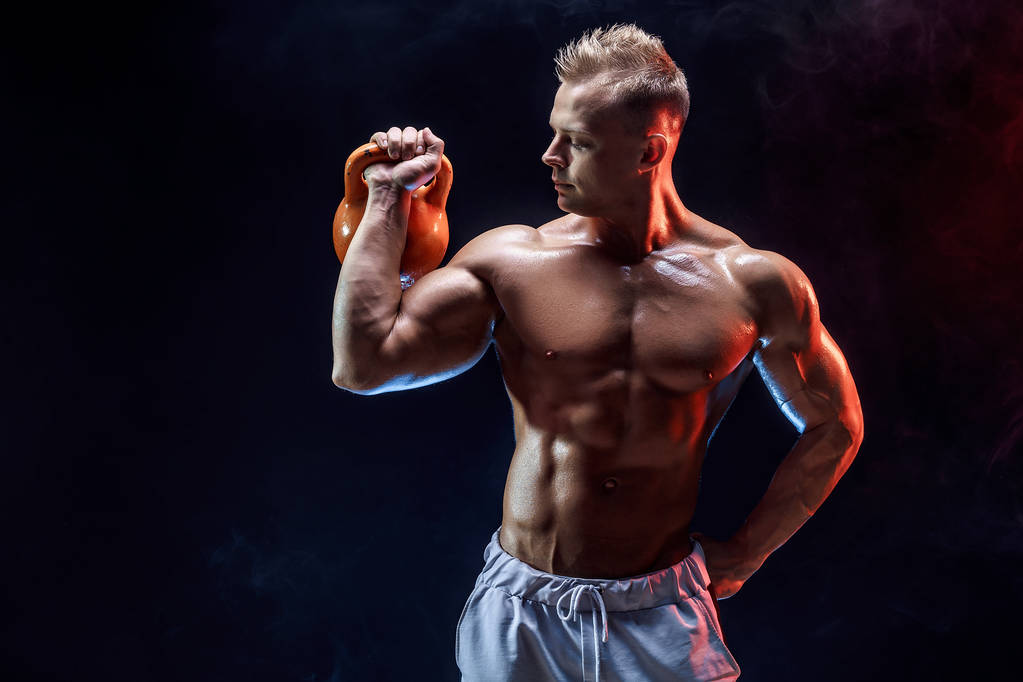 Hombre muscular concentrado haciendo ejercicio con kettlebell - Foto, Imagen