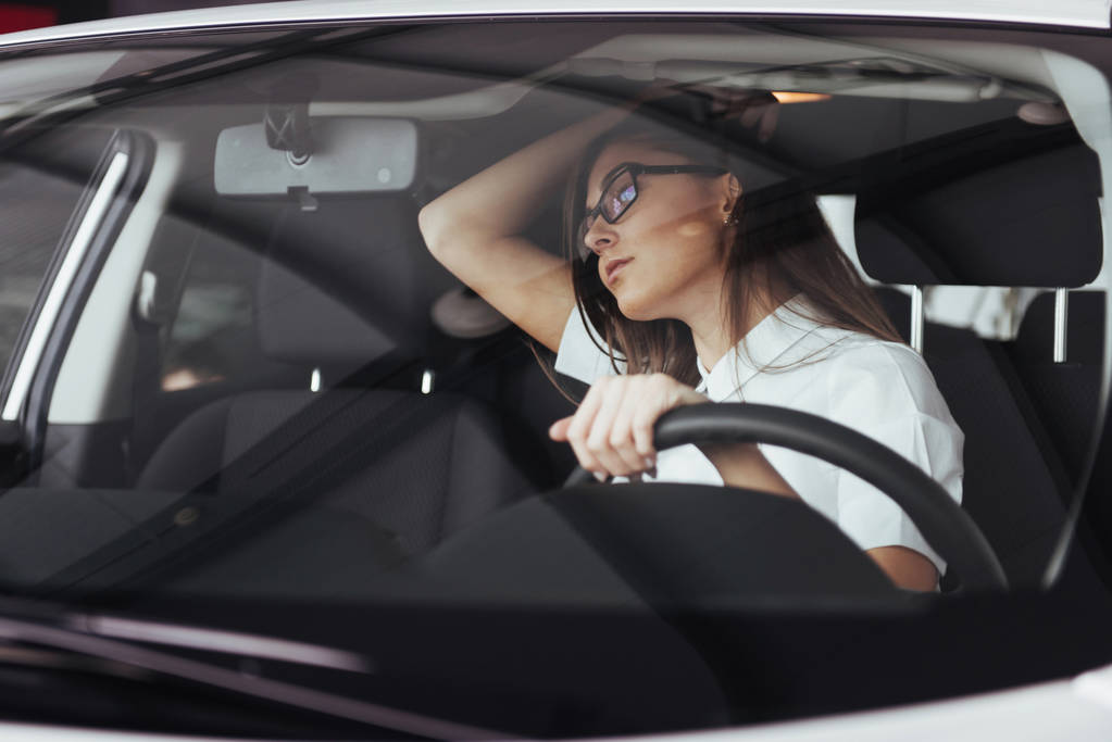 atractiva joven mujer caucásica mirando a la cámara desde el asiento delantero del coche
 - Foto, imagen