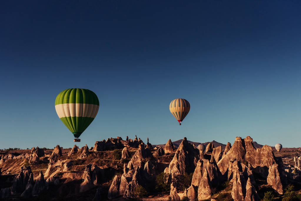 Balão de ar quente sobrevoando a paisagem rochosa na Capadócia Turquia. Vale, desfiladeiro, colinas, localizado entre as montanhas vulcânicas no Parque Nacional Goreme
. - Foto, Imagem