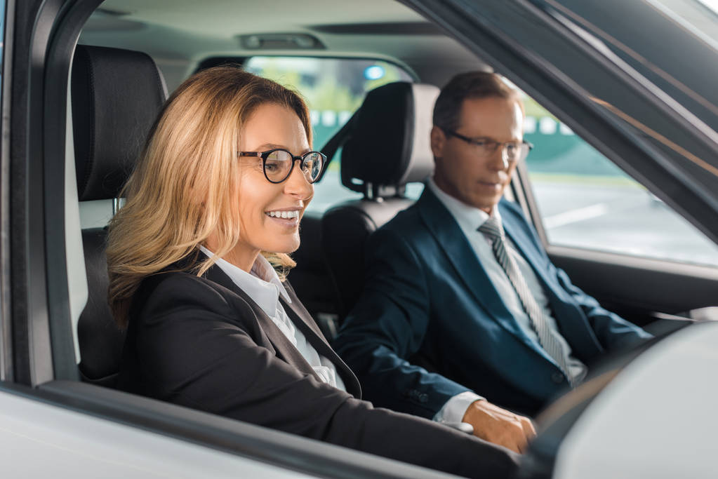 sorridente coppia di lavoro seduto in una nuova auto per test drive
 - Foto, immagini