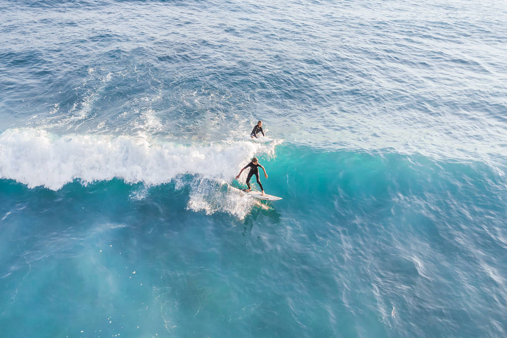Deux surfeurs au sommet de la vague dans l'océan, vue de dessus
 - Photo, image