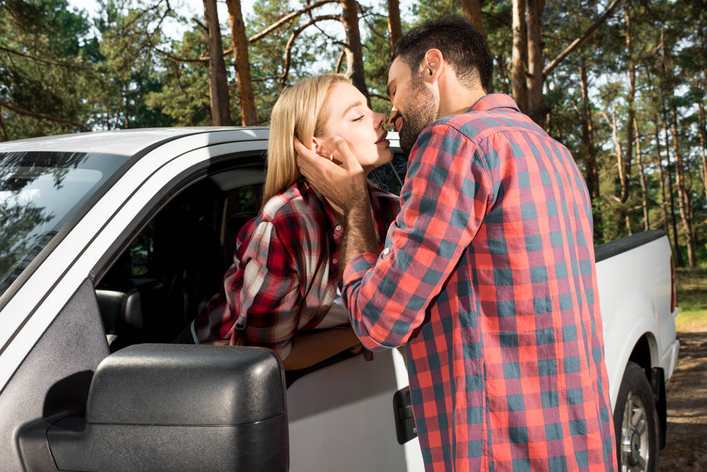 çekici kız oturan öpüşme genç adam açık havada arabayı al  - Fotoğraf, Görsel