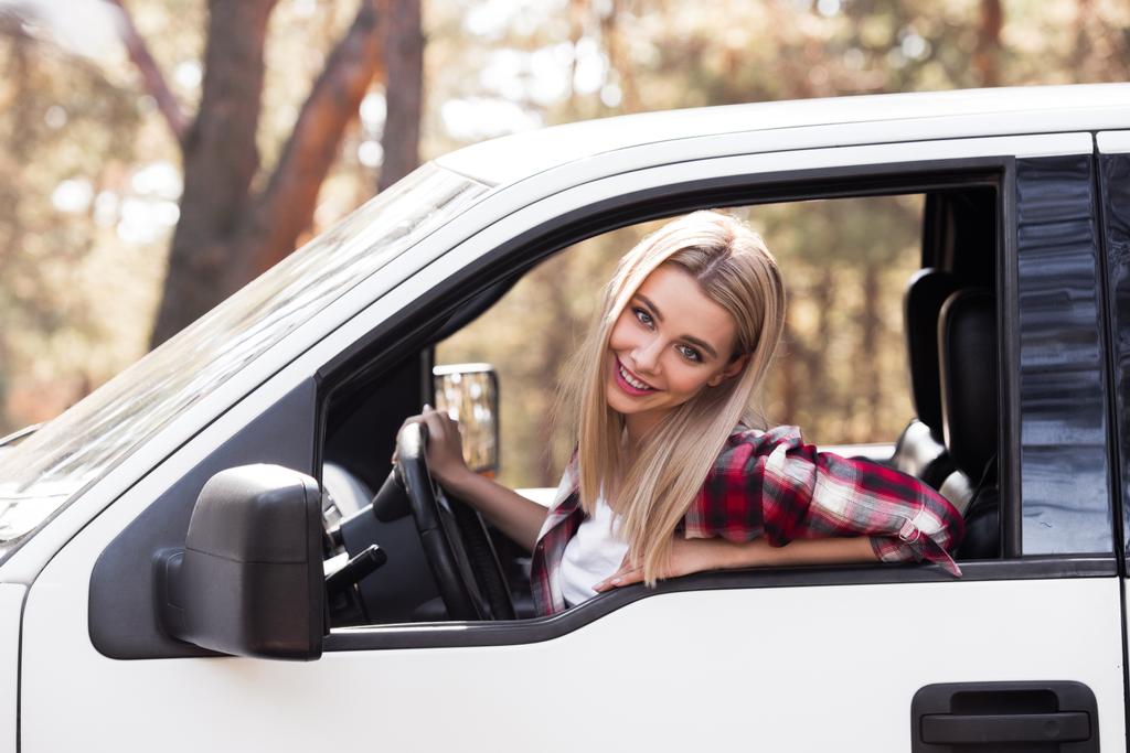 beautiful young driver sitting in pickup truck in forest - Photo, Image