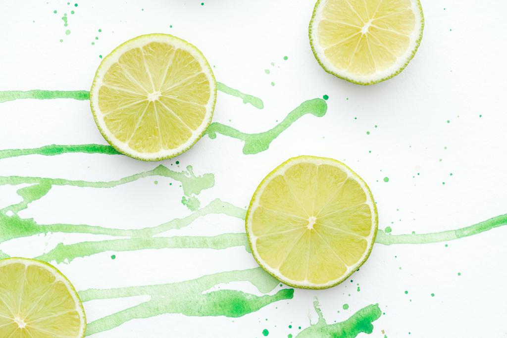 pohled shora kusů řez zralé citrusy na bílém povrchu s zeleným akvarel - Fotografie, Obrázek