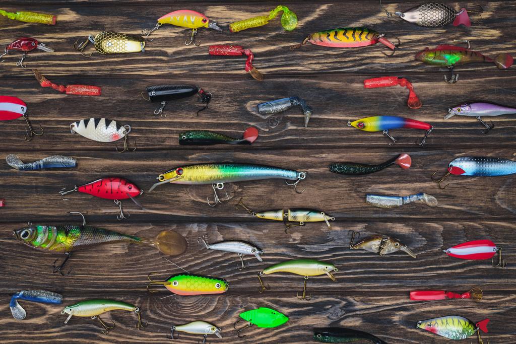 flat lay with arranged various fishing bait on wooden background  - Photo, Image
