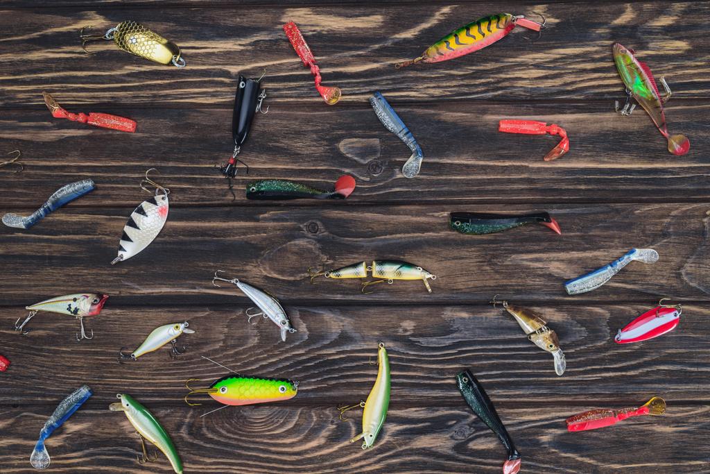 elevated view of arranged various fishing bait on wooden background  - Photo, Image