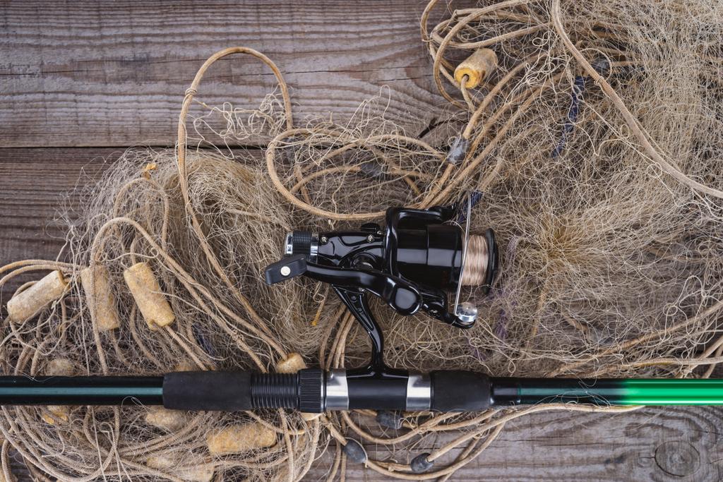 木の板に釣り竿と釣りのネットの上から見る  - 写真・画像