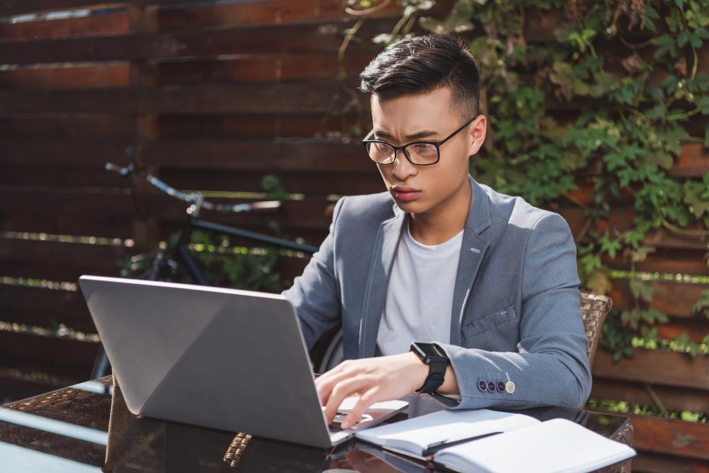 focado asiático empresário remoto trabalhando no laptop na mesa com notebook no café
 - Foto, Imagem