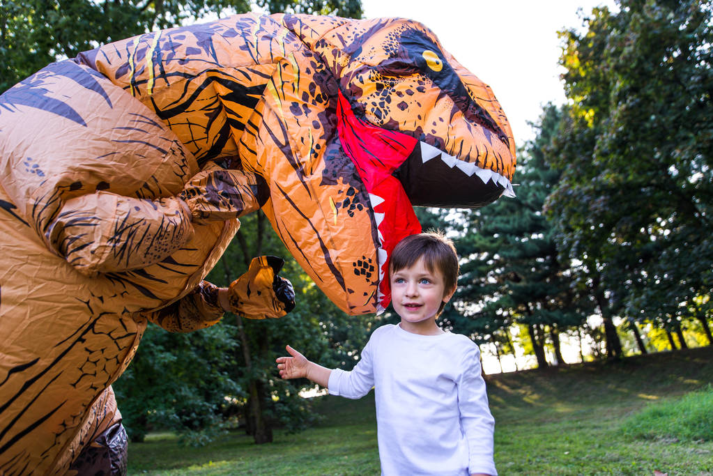Ojciec i syn gra w parku, z kostium dinozaura, zabawy z rodziną odkryty - Zdjęcie, obraz
