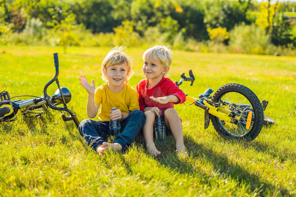 Dva malé chlapce pitné vody v parku po na kolech - Fotografie, Obrázek