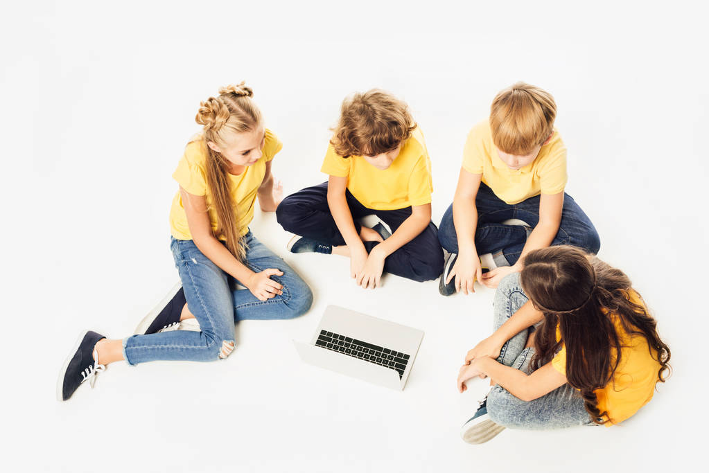 visão de alto ângulo do grupo de crianças bonitos sentados e usando laptop juntos isolados em branco
 - Foto, Imagem