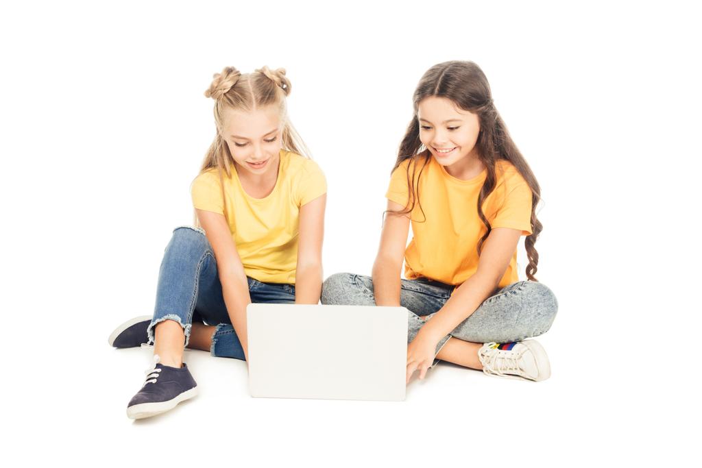 beautiful smiling kids using laptop together isolated on white - Photo, Image