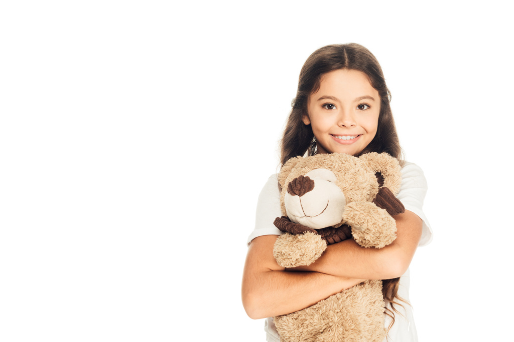 χαμογελώντας αξιολάτρευτο παιδί αγκαλιάζει αρκουδάκι απομονωθεί σε λευκό και βλέπουν τα φωτογραφικών μηχανών - Φωτογραφία, εικόνα